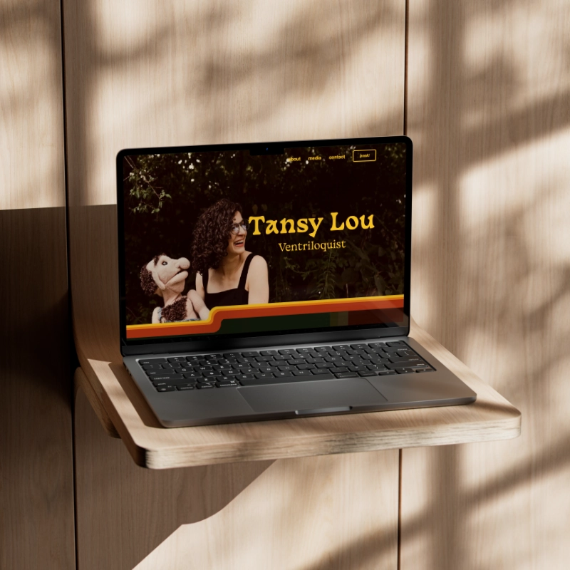 Tansy Lou website displayed on laptop outside